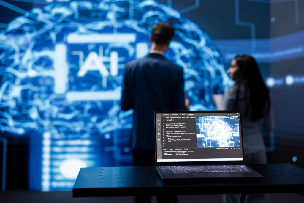 Laptop displaying AI cognitive computing technology, with IT staff members working in the blurry background, highlighting the use of advanced AI tools for cybersecurity